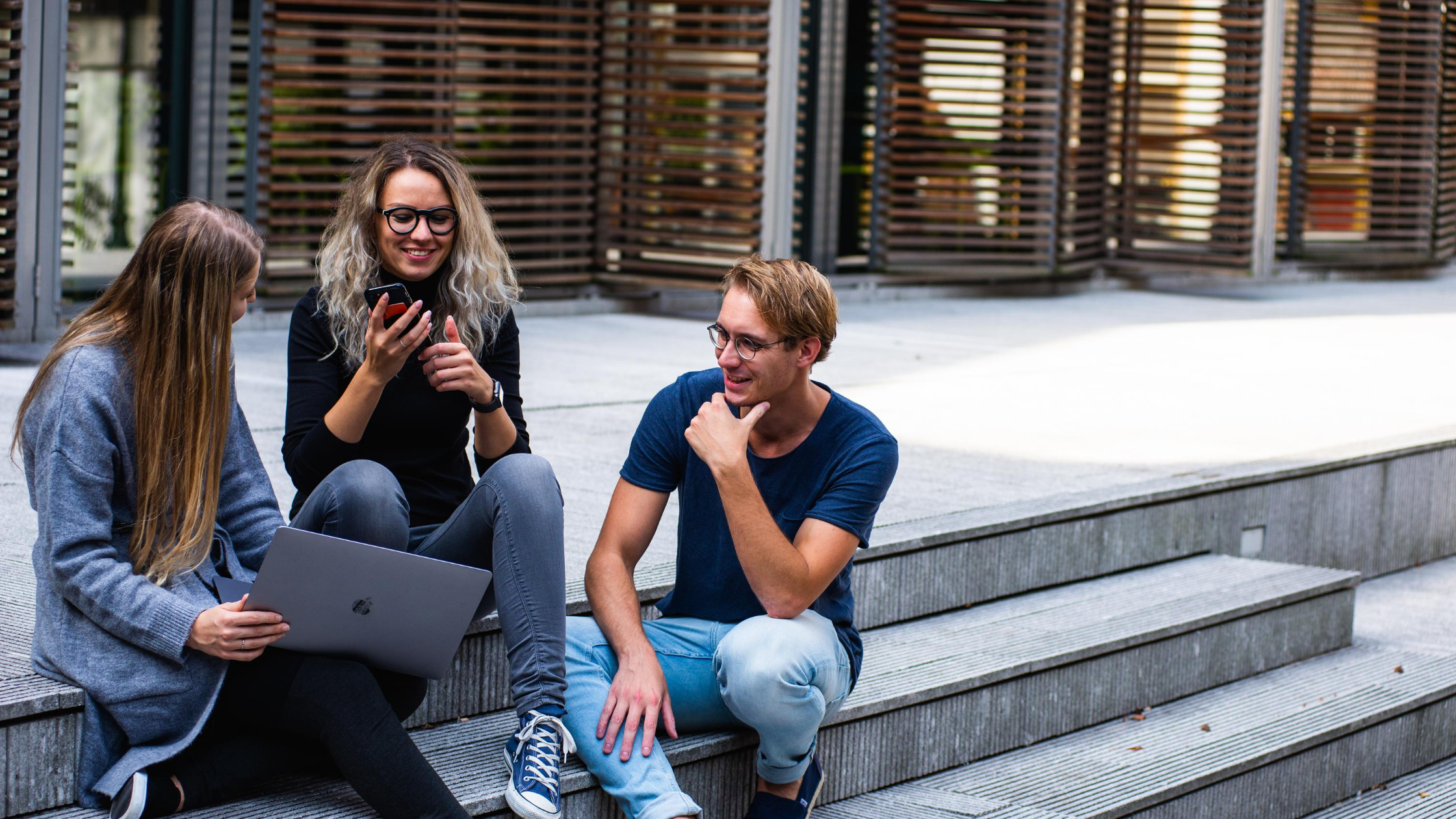 three people sitting talking with each other