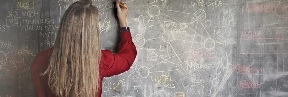 woman writes on blackboard